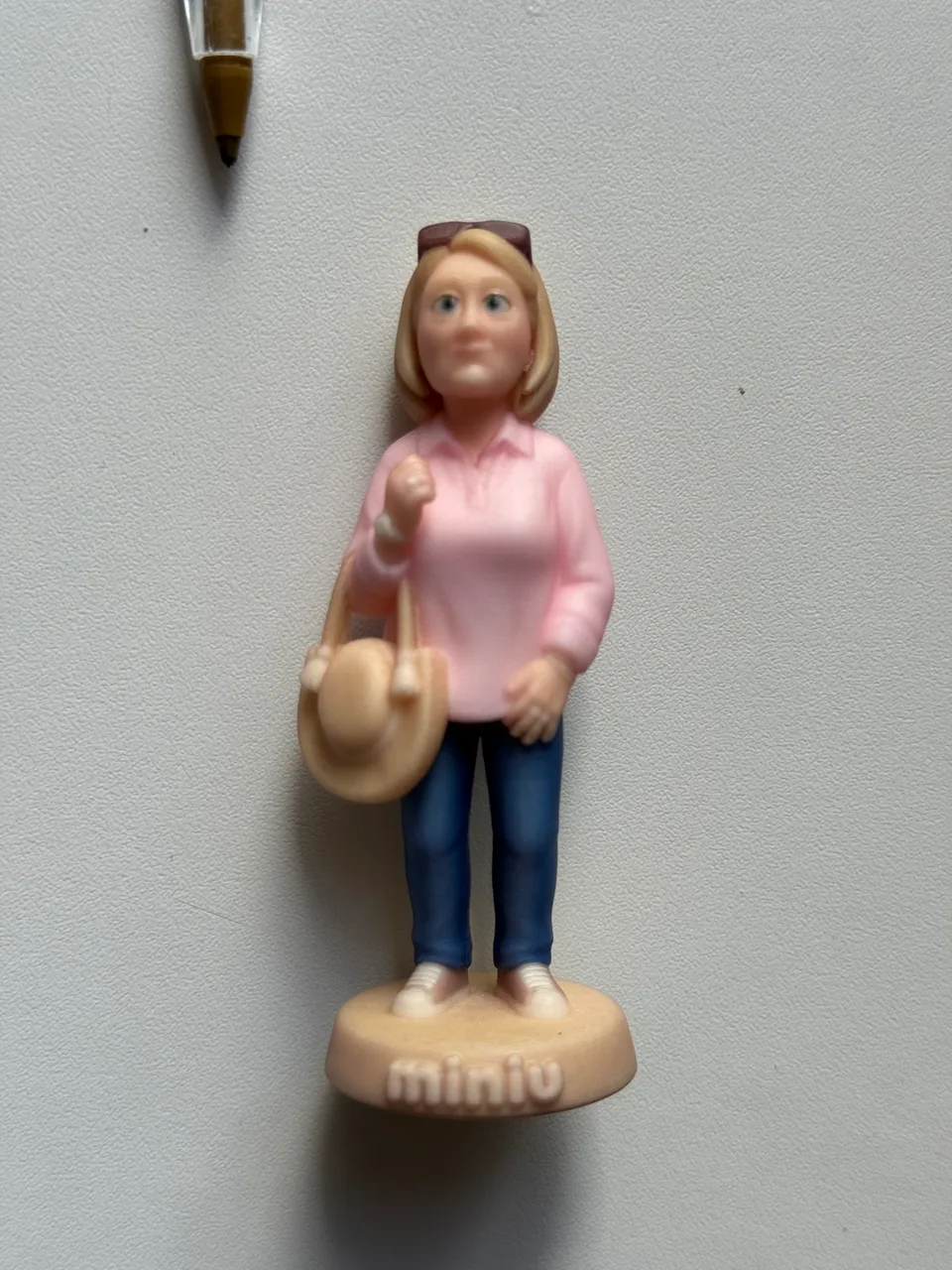 Figurine personnalisée imprimée de 8 cm : femme blonde en polo rose et jean, lunettes sur la tête et sac en paille, socle gravé miniu